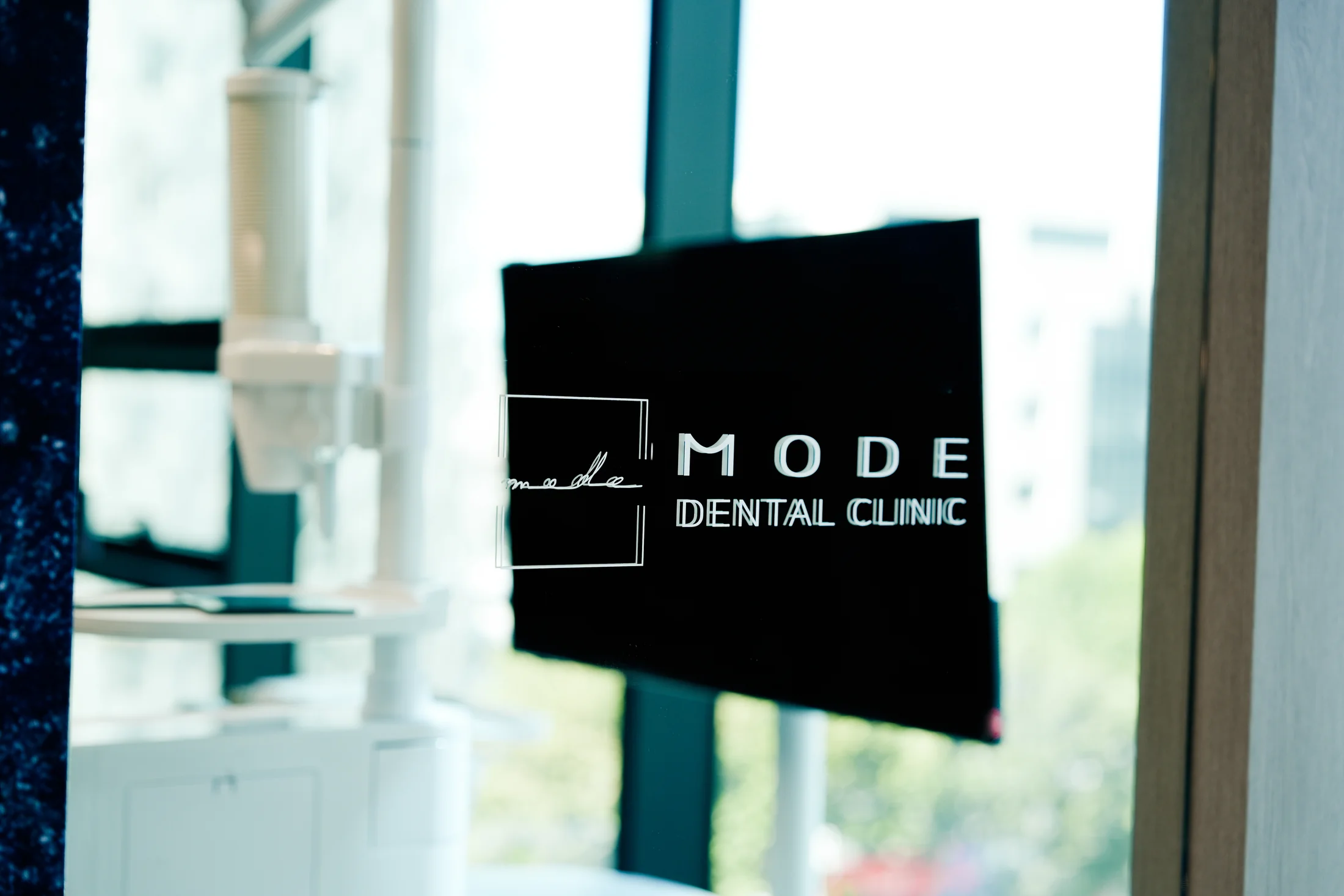 MODE DENTAL CLINIC 로고가 부착된 유리문